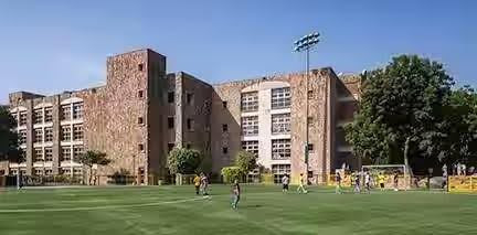 A school building with children playing in ground