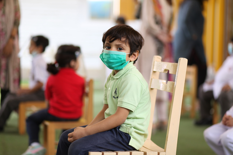 Kid sitting in school wearing a mask