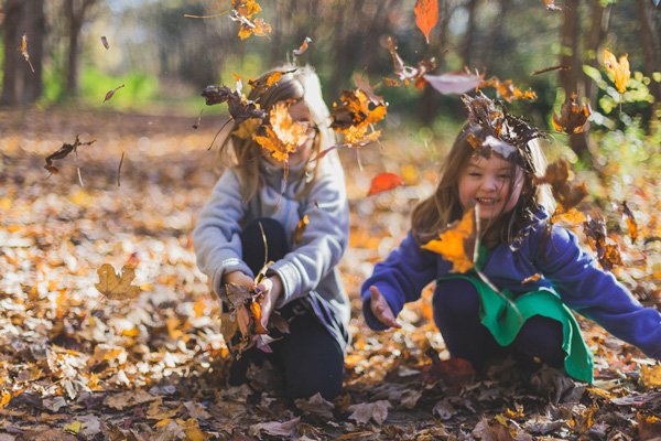 Kids playing on the with leaves