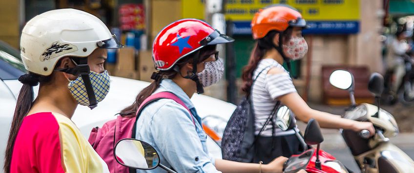 Women driving two-wheelers with masks